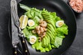 Fresh seafood salad with grilled shrimps prawns, egg, avocado and cucumber in a plate. Black background. top view Royalty Free Stock Photo