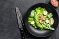 Fresh seafood salad with grilled shrimps prawns, egg, avocado and cucumber in a plate. Black background. top view. Copy space Royalty Free Stock Photo