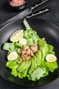 Fresh seafood salad with grilled shrimps prawns, egg, avocado and cucumber in a plate. Black background. top view Royalty Free Stock Photo