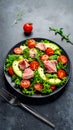 Fresh seared tuna salad with avocado tomatoes and arugula on a dark stone background Royalty Free Stock Photo