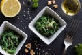 Fresh seaweed salad in two square bowls on a dark background