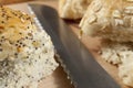 Fresh seeded bread rolls laying next to a knife Royalty Free Stock Photo