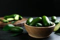 Fresh seedless avocados with green leaves in wooden bowl on grey table. Space for text Royalty Free Stock Photo