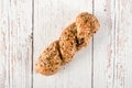 Fresh seedy bread on white wooden background