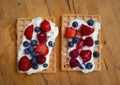 Fresh selfmade waffles with cream, strawberries and blueberries on wooden table Royalty Free Stock Photo