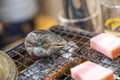 Fresh shell and pork are grilled on mini strove, in local Japanese restaurant Royalty Free Stock Photo