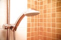 Fresh shower where Water running from shower head and faucet in modern bathroom with orange wall Royalty Free Stock Photo