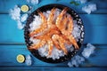 Fresh shrimp with ice in bowl on blue wooden table Royalty Free Stock Photo