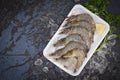 Fresh shrimp prawns for cooking with spices lemon on dark background in the seafood restaurant, raw shrimps on plate plastic tray