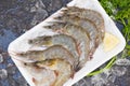 Fresh shrimp prawns for cooking with spices lemon on dark background in the seafood restaurant, raw shrimps on plate plastic tray