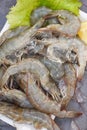 Fresh shrimp prawns for cooking with spices lemon vegetable salad lettuce on dark background in the seafood restaurant, Close up Royalty Free Stock Photo