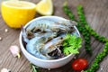 Fresh shrimp on white bowl and wooden background with ingredients herb and spices for cooking seafood - raw shrimps prawns Royalty Free Stock Photo