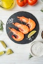 Fresh shrimps with lime and rosemary on white wooden table