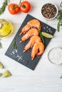 Fresh shrimps with lime and rosemary on white wooden table