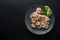 Fresh shrimps in plate over dark background. Healthy food. Top view. Copy space Royalty Free Stock Photo