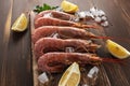 Fresh shrimps on wooden background with lemon slice. Seafood background