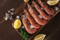 Fresh shrimps on wooden background with lemon slice. Seafood background