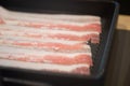 Fresh sliced bacon preparing for boiling in Shabu-shabu hot pot or sukiyaki in black tray Royalty Free Stock Photo