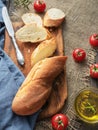 Fresh sliced baguette, tomatoes and olive oil, ingredients for making a sandwich, closeup. Rough fabric background Royalty Free Stock Photo