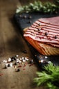 fresh sliced beef pastrami surrounded by herbs in wooden chopping board Royalty Free Stock Photo