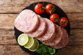 Fresh sliced brawn served with tomatoes, lime and cilantro closeup on a slate board. Horizontal top view