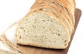 Fresh sliced bread and wheat on wooden cutting board on white wooden table Royalty Free Stock Photo