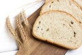 Fresh sliced bread and wheat on wooden cutting board on white wooden table, top view Royalty Free Stock Photo