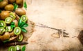 Fresh sliced kiwi with a knife and a full basket and leaves. Royalty Free Stock Photo