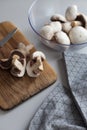 Fresh sliced mushrooms at wooden cutting board. Chopping food ingredients. Food background of fresh champignons Royalty Free Stock Photo