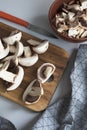 Fresh sliced mushrooms at wooden cutting board. Chopping food ingredients. Food background of fresh champignons Royalty Free Stock Photo