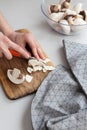 Fresh sliced mushrooms at wooden cutting board. Woman chopping food ingredients. Royalty Free Stock Photo