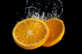 Fresh sliced orange fruit in water splash isolated on black background. Minimal food concept Royalty Free Stock Photo