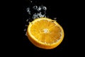 Fresh sliced orange fruit in water splash isolated on black background. Minimal food concept Royalty Free Stock Photo