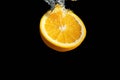 Fresh sliced orange fruit in water splash isolated on black background. Minimal food concept Royalty Free Stock Photo