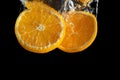 Fresh sliced orange fruit in water splash isolated on black background. Minimal food concept Royalty Free Stock Photo