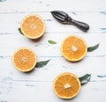 Fresh sliced oranges with leaves and wooden crush for fruit, rustic wooden background, top view Royalty Free Stock Photo