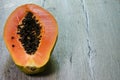 Fresh sliced papaya with seeds inside on a wooden background Royalty Free Stock Photo