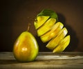 Fresh sliced ripe pear with leaves hanging in the air Royalty Free Stock Photo