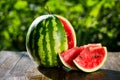 Fresh sliced watermelon wooden background,Ripe striped watermelon,Close-up of fresh slices of red watermelon,sweet harvest. Water Royalty Free Stock Photo