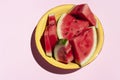 Fresh sliced watermelon in yellow bolw on pink background. Banner, copy space .Summer fruit