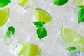 Fresh slices of green limes and mint over crushed ice cubes Royalty Free Stock Photo