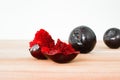 Fresh slices of red plum. Group of broken plum fruit on a wooden background. Juicy slices of red juicy plum. Ingredients