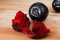 Fresh slices of red plum. Group of broken plum fruit on a wooden background. Juicy slices of red juicy plum. Ingredients