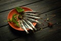 Fresh small sea fish in a plate on a black background with spices and herbs. Top view. Seafood healthy eating concept Royalty Free Stock Photo