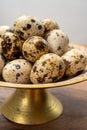 Fresh small spotted partridge eggs on bronze plate Royalty Free Stock Photo