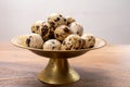 Fresh small spotted partridge eggs on bronze plate Royalty Free Stock Photo