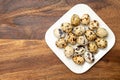 Fresh small spotted partridge eggs on white board