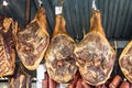 Fresh smoked meats and salami hanging on display in butcher`s shop