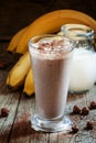 Fresh smoothie banana and chocolate, milk and nuts in a large glass on the old wooden background, selective focus Royalty Free Stock Photo