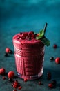 Fresh smoothie currant, raspberries and mint in glass on dark blue background. Royalty Free Stock Photo